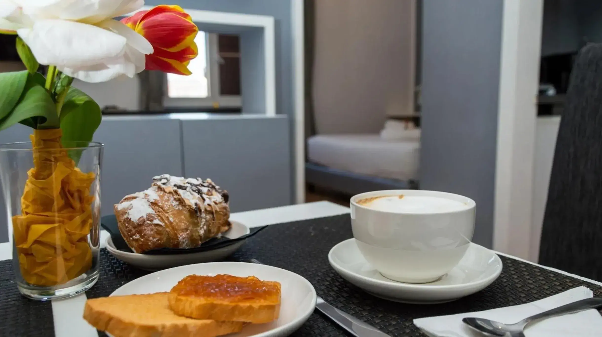 Cappuccino e cornetto sul tavolo di una suite