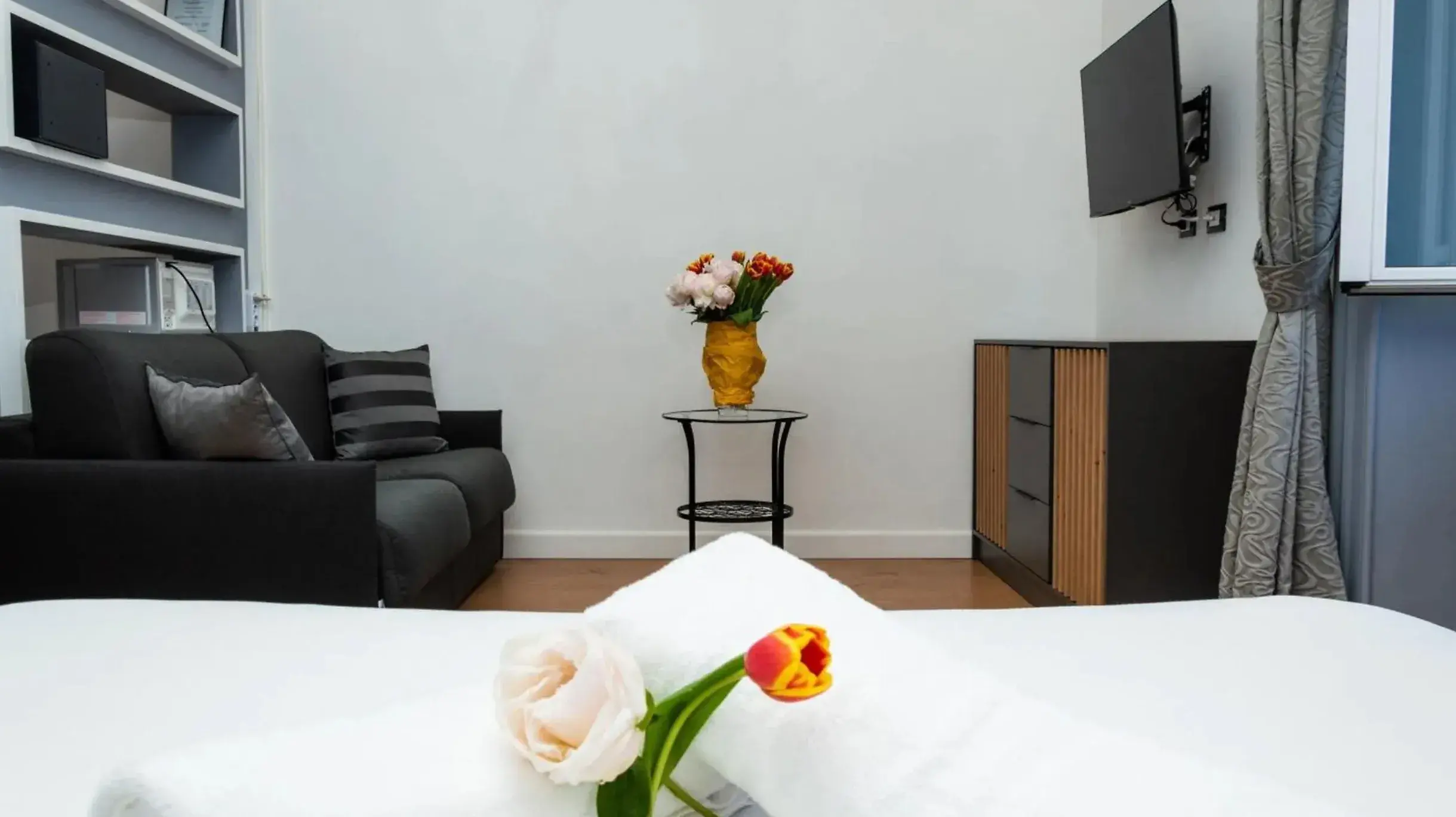 Zona giorno con divano letto e TV in una suite del Cicer One